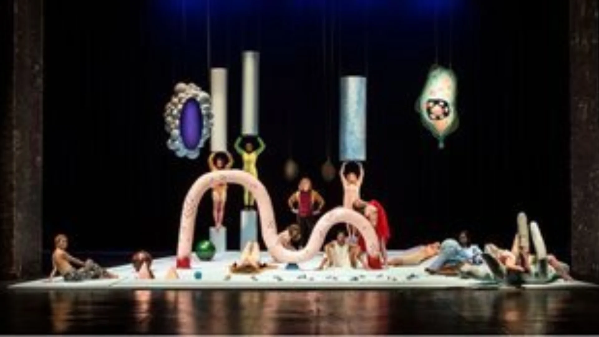 People on a stage with various objects