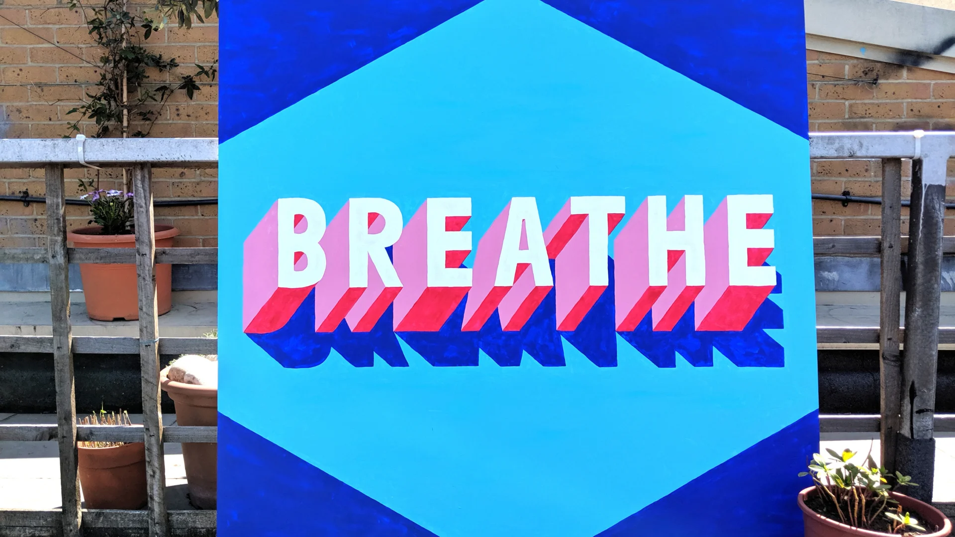 A panting showing the word 'BREATHE' in white and pink on a blue background.