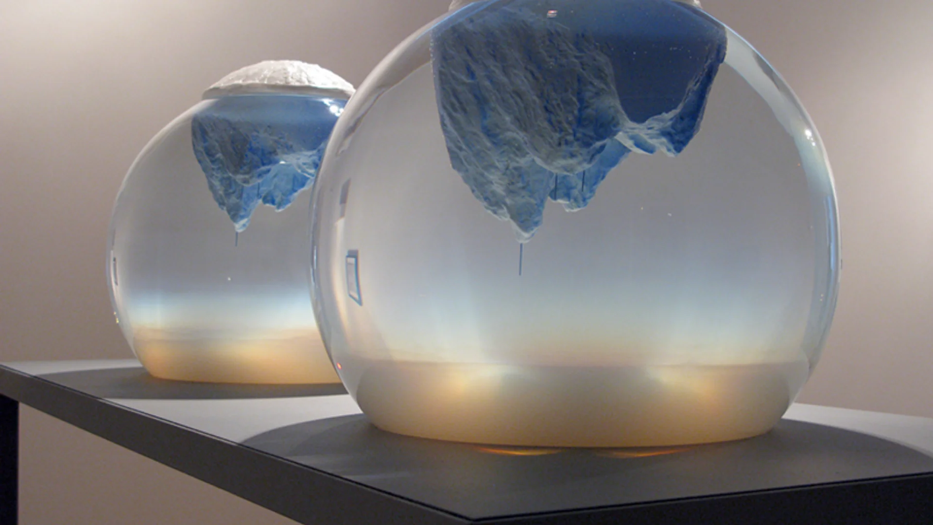 Two spherical glass jars with blue ice shapes