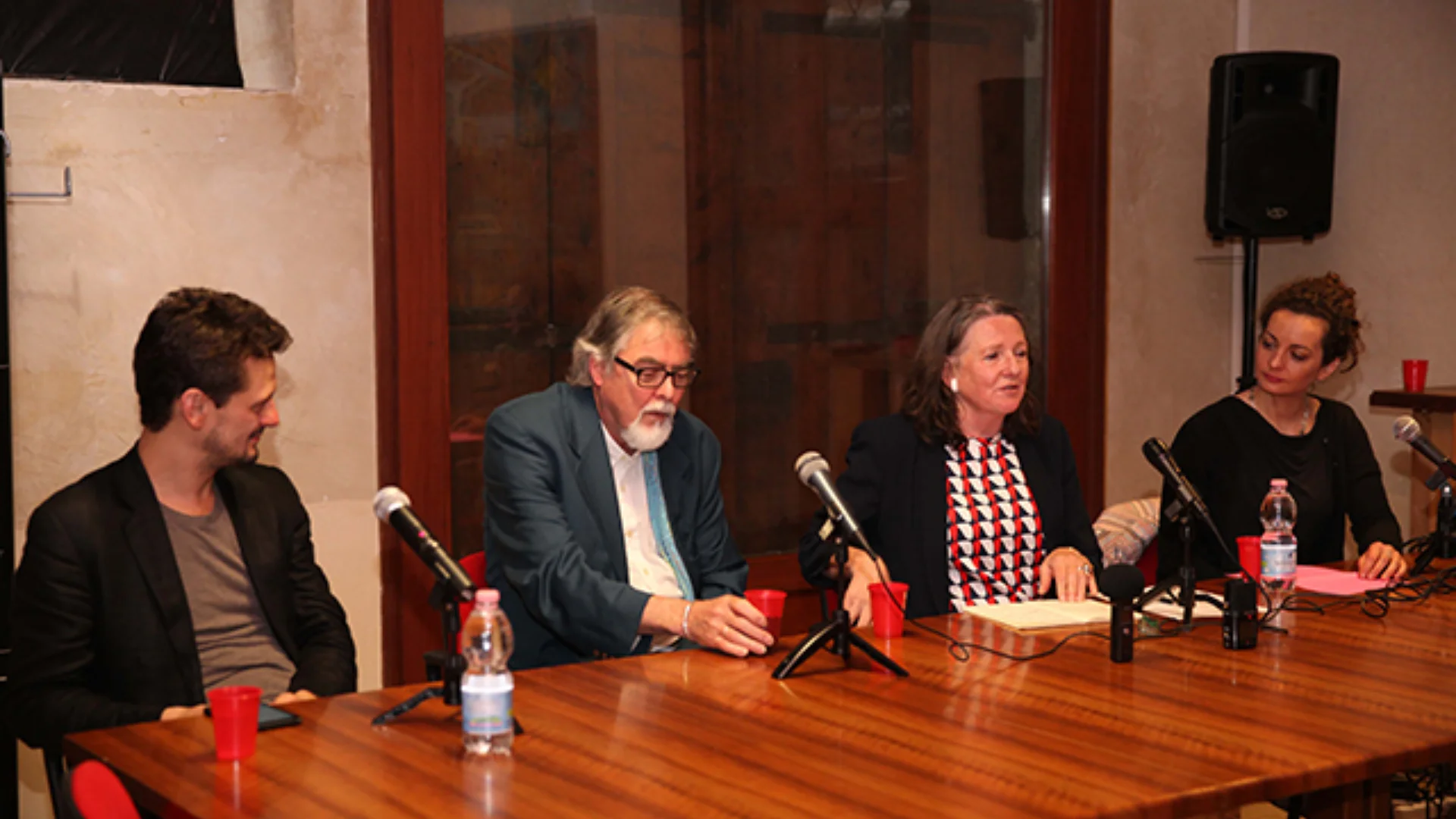 Four people speaking and sitting around a conference table