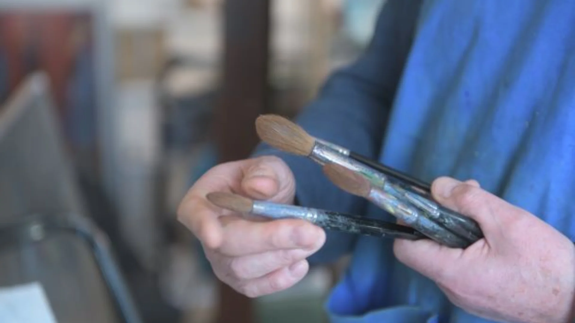 Painter holding clean paint brushes