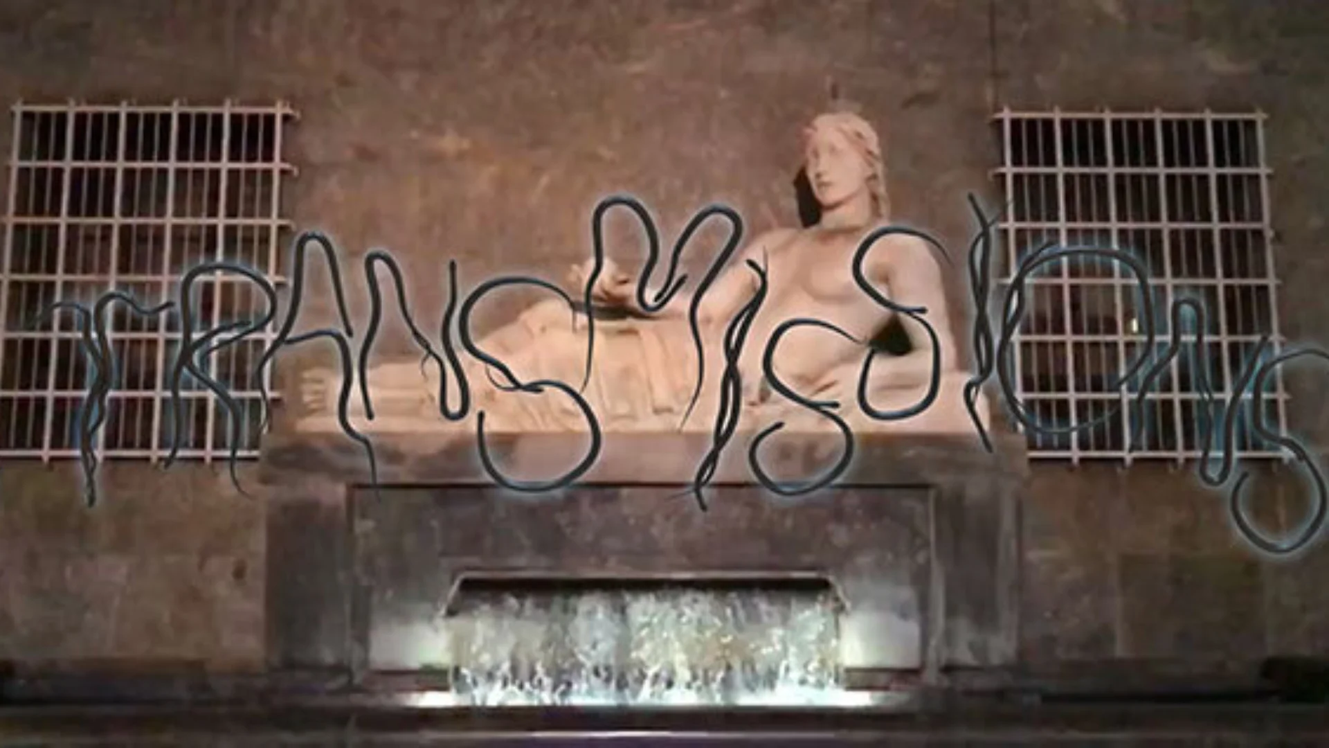 Ancient statue of a reclining lady atop a carved plinth. The foreground has squiggly letter spelling Transmissions