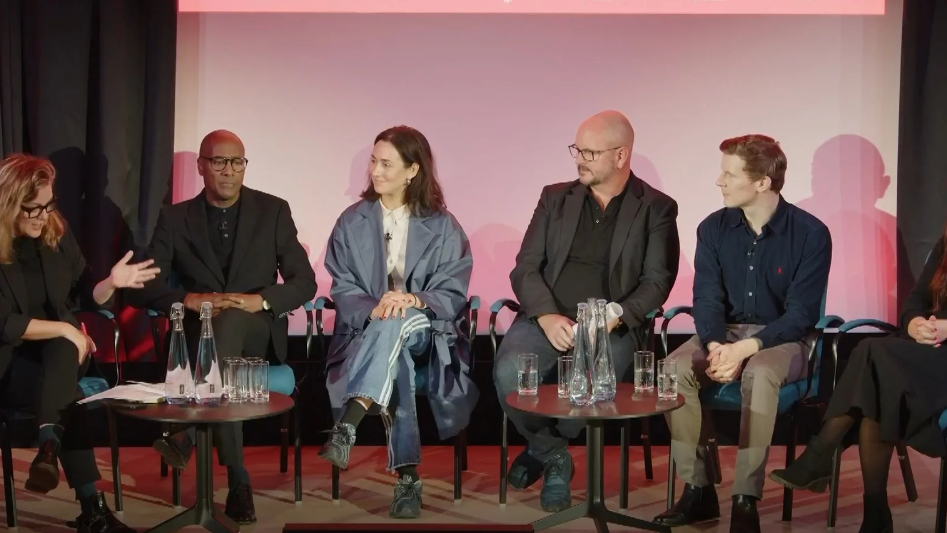 Six people sitting on a stage and discussing