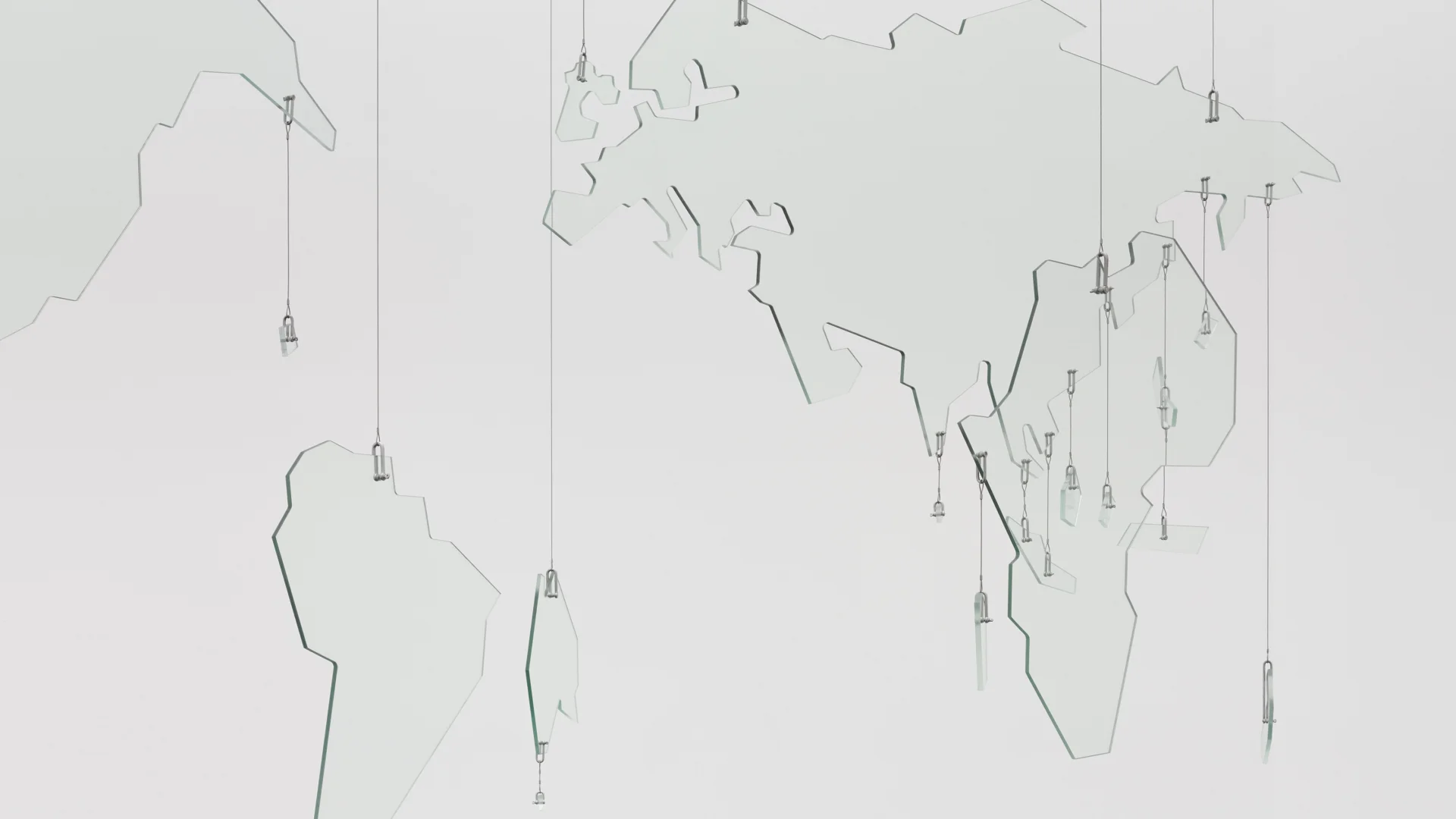 a photograph of an installation artwork. The piece depicts a map of the world in clear glass, suspended in space by steel wires.